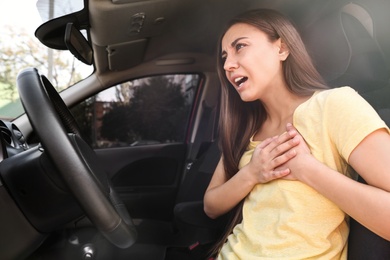 Photo of Young woman suffering from heart attack in car