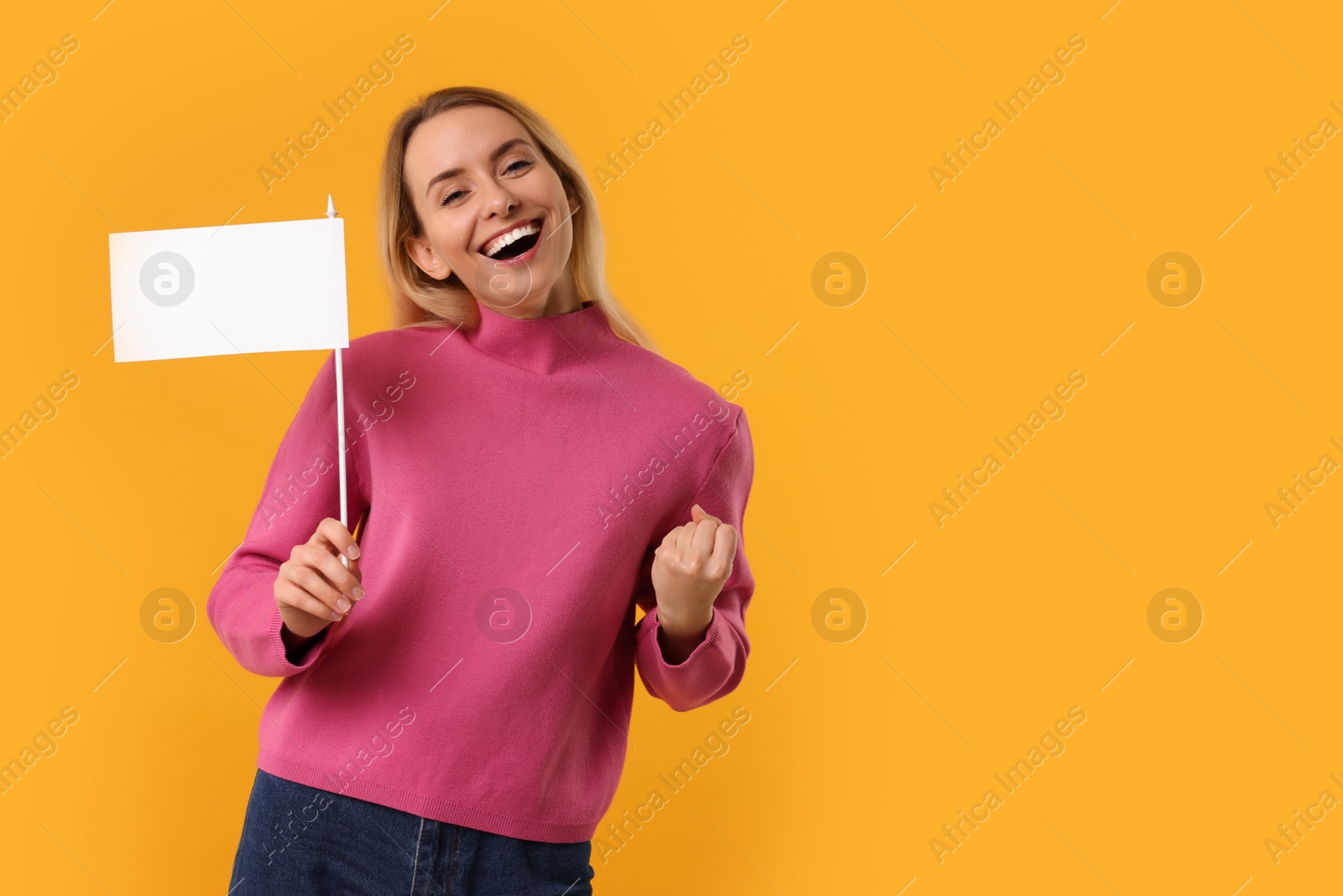 Photo of Happy woman with blank white flag on orange background. Mockup for design