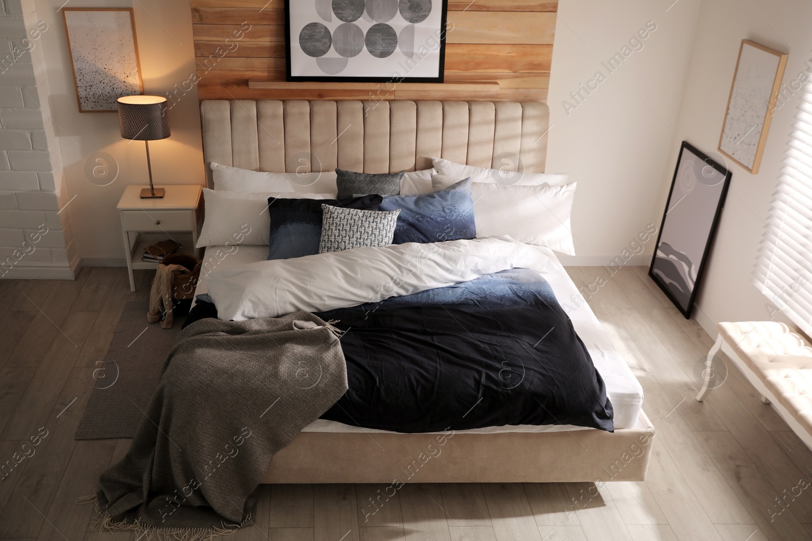 Photo of Comfortable bed with pillows and soft blanket in room. Stylish interior design