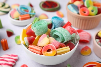 Bowl of tasty colorful jelly candies on white table, closeup