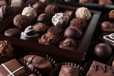 Photo of Different tasty chocolate candies as background, closeup