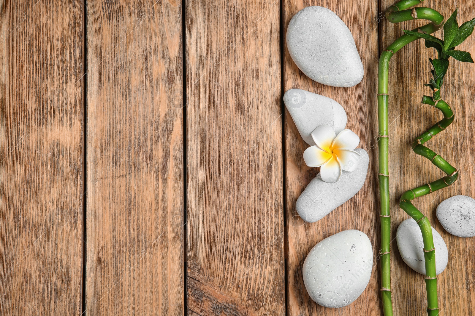 Photo of Flat lay composition with spa stones and space for text on wooden background