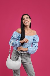 Photo of Fashionable young woman with stylish bag on pink background