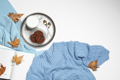 Flat lay composition with soft knitted sweater on white background