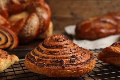 Photo of Freshly baked spiral bun and other pastries on table, closeup