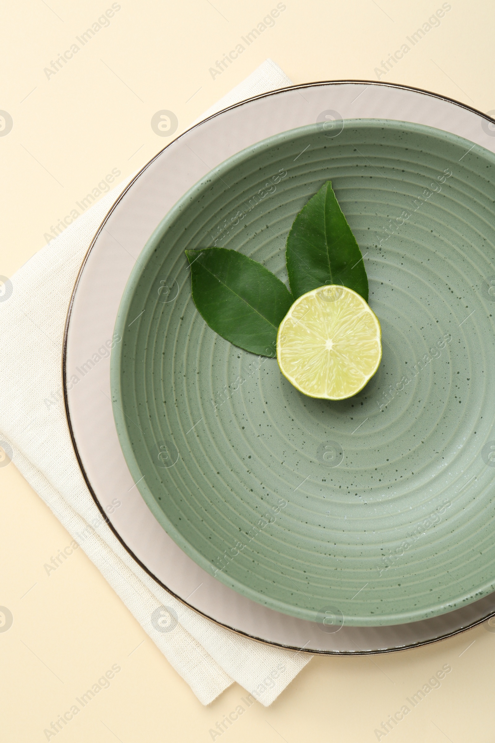 Photo of Stylish ceramic plate, bowl, cutlery and decor on beige background, top view