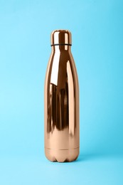 Photo of Metal bottle on light blue background. Conscious consumption