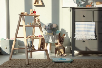 Photo of Beautiful baby room interior with stylish wooden ladder