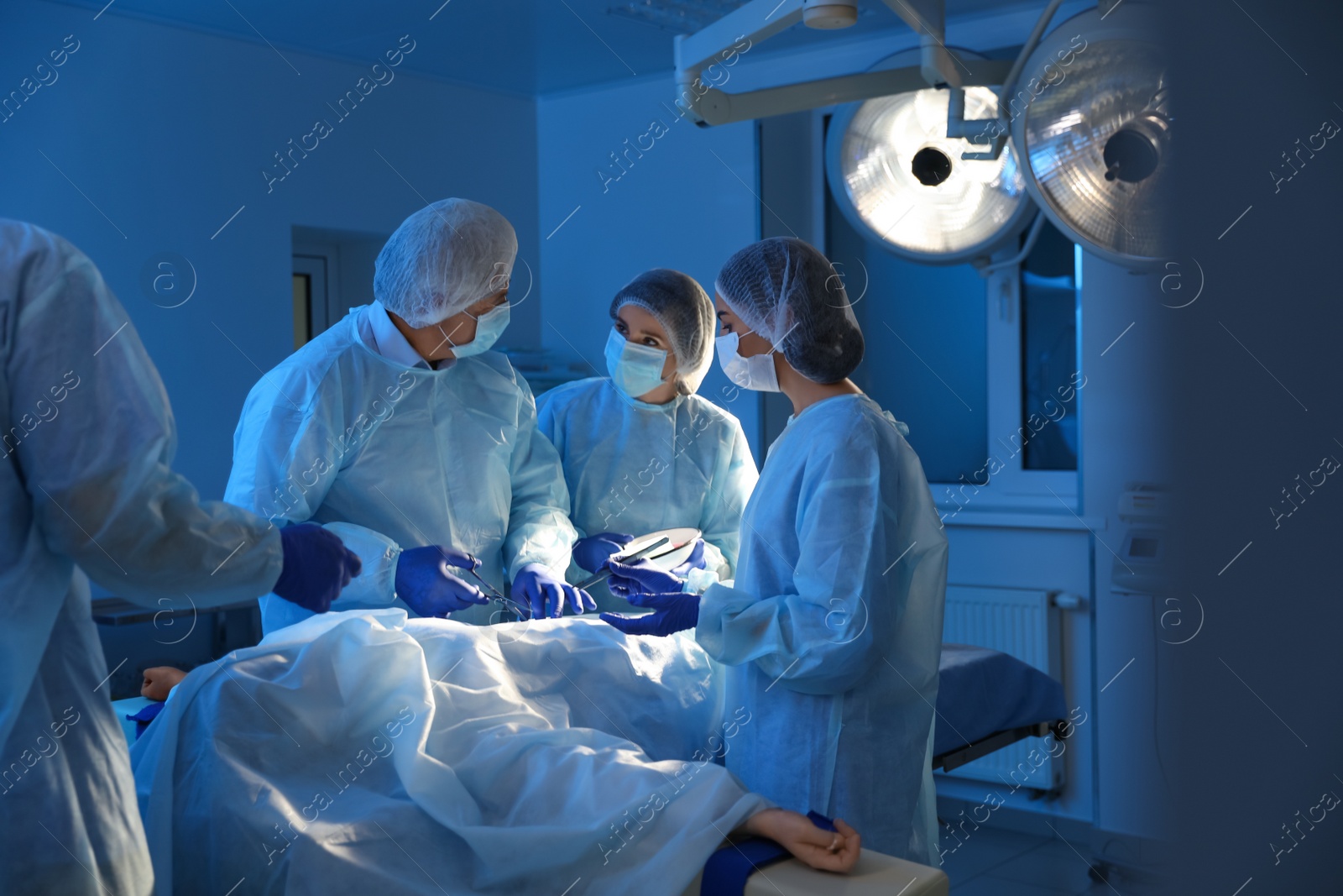 Photo of Team of professional doctors performing operation in surgery room