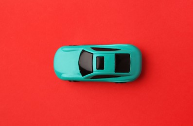 Photo of One light blue car on red background, top view