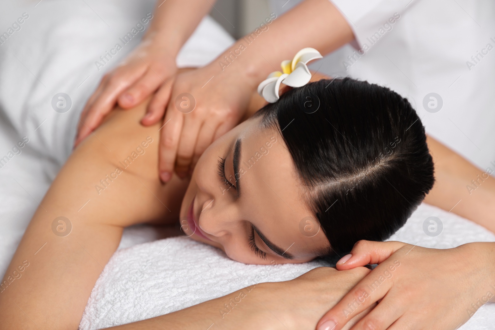 Photo of Beautiful woman receiving back massage in beauty salon, closeup