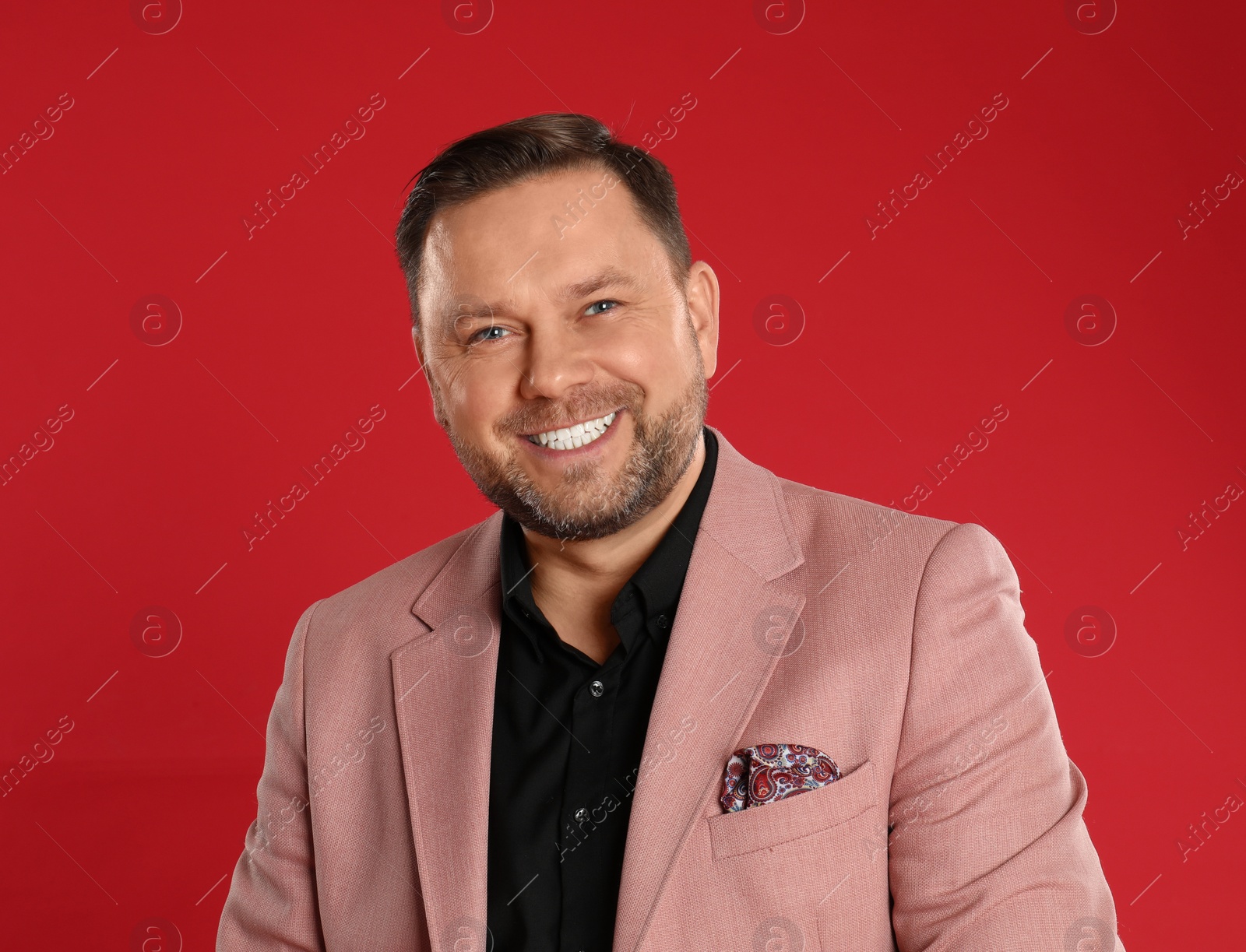 Photo of Portrait of happy mature man on red background