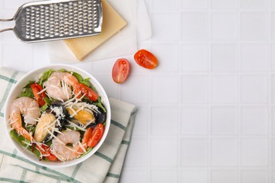 Photo of Bowl of delicious salad with seafood on white tiled table, flat lay. Space for text