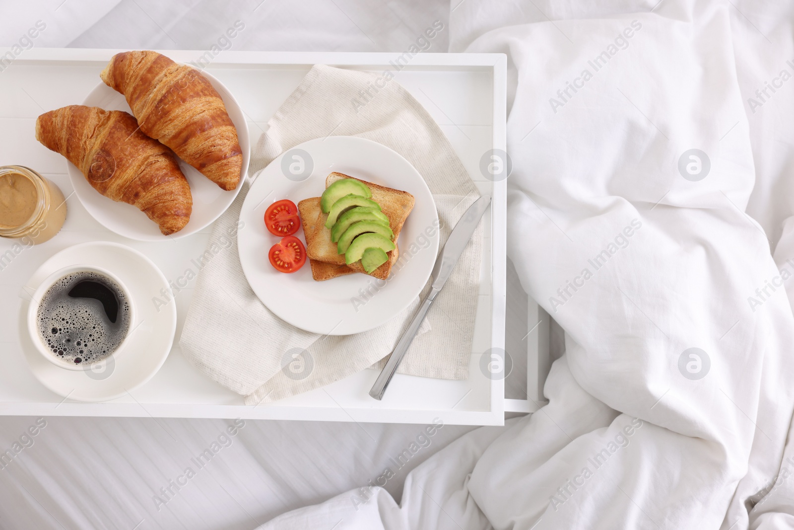 Good morning. Tray with tasty breakfast on bed, top view Photo of Good morning. Tray with tasty breakfast on bed, top view