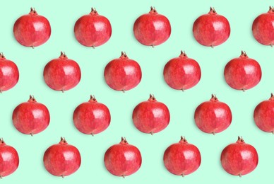Image of Delicious ripe pomegranates on turquoise background, flat lay 
