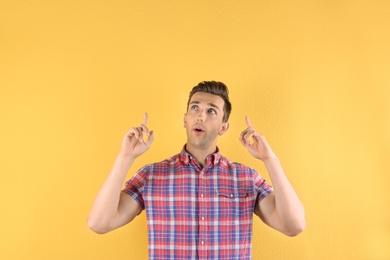 Photo of Handsome emotional young man on color background