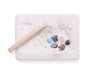 Photo of Educational toy for motor skills development. Excavation kit (plaster, wooden chisel and gemstones) isolated on white, top view