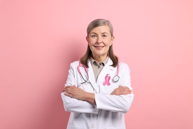 Photo of Mammologist with pink ribbon on color background. Breast cancer awareness