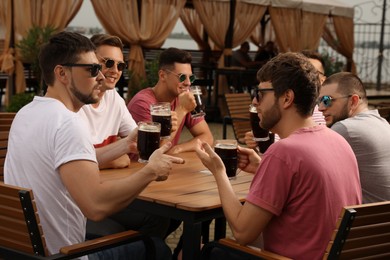 Friends with glasses of beer in outdoor cafe