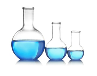 Photo of Flasks with blue liquid on table against white background. Laboratory analysis