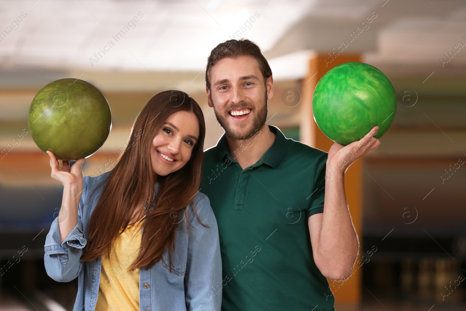 Photo of Young couple with balls in bowling club