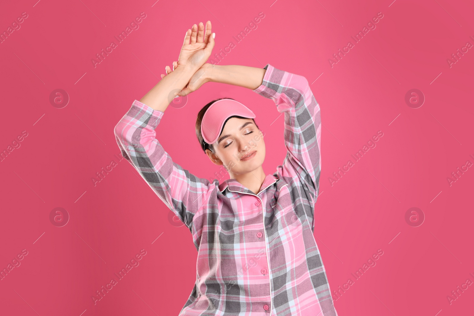 Photo of Beautiful woman wearing sleeping mask on pink background. Bedtime