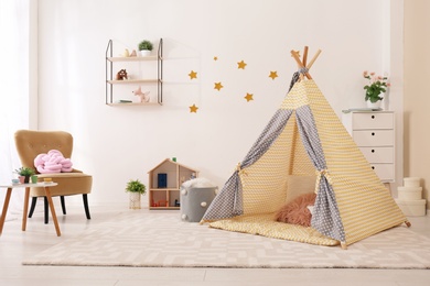 Photo of Cozy kids room interior with play tent and toys