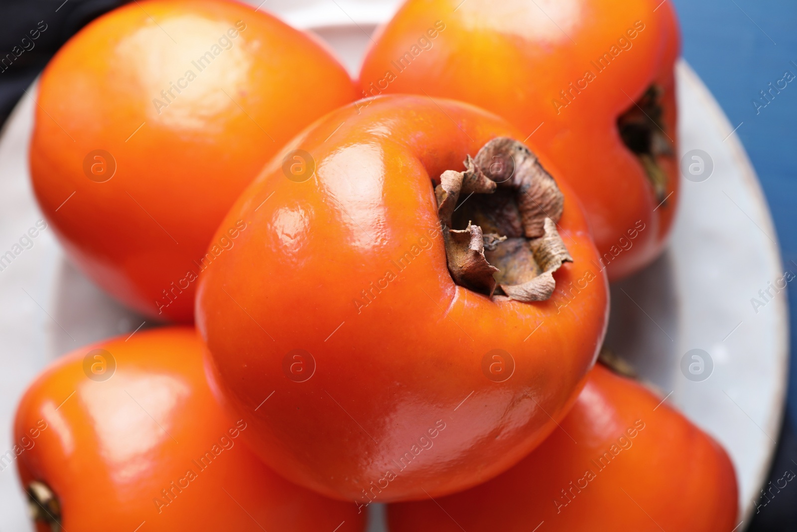 Photo of Delicious ripe persimmons on table, closeup view