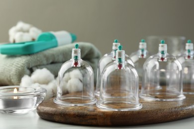 Photo of Many plastic cups on white table. Cupping therapy