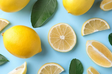 Flat lay composition with fresh lemons on light blue background