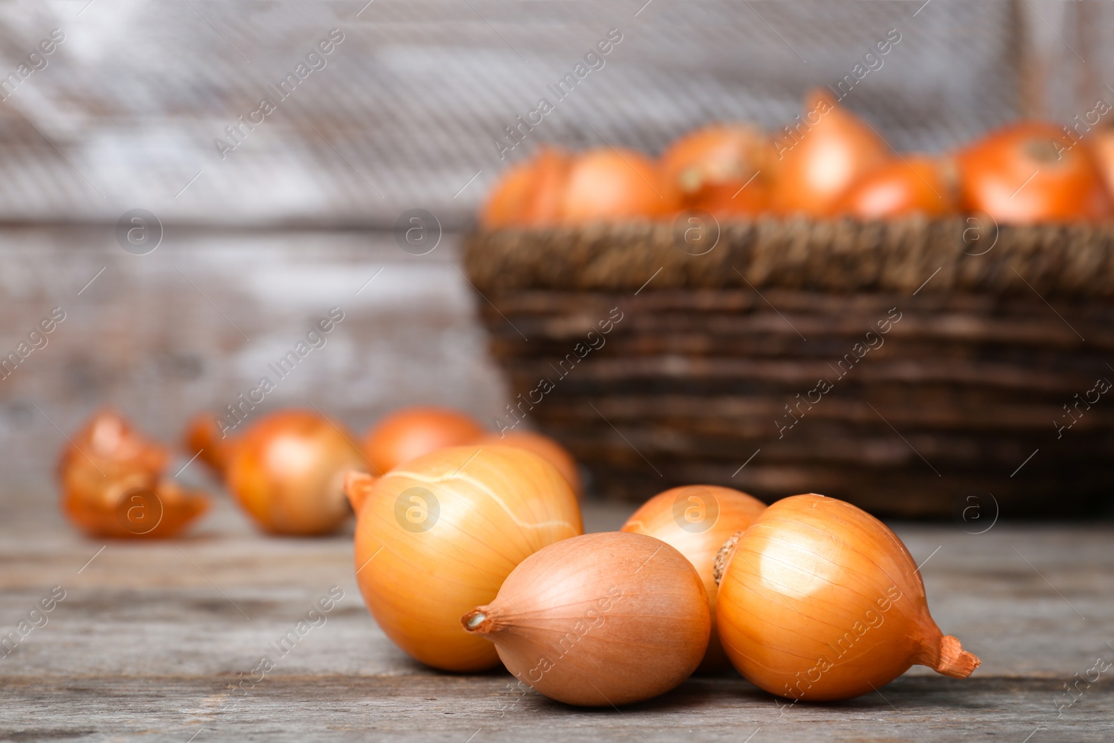 Photo of Fresh ripe onions on wooden table