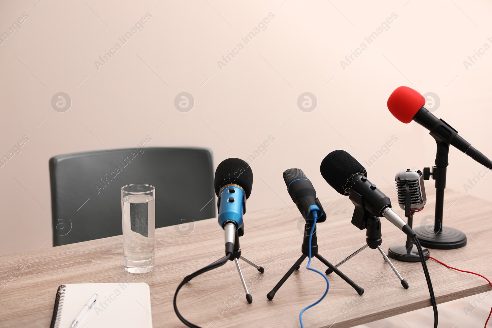 Photo of Journalist's microphones on wooden table in room