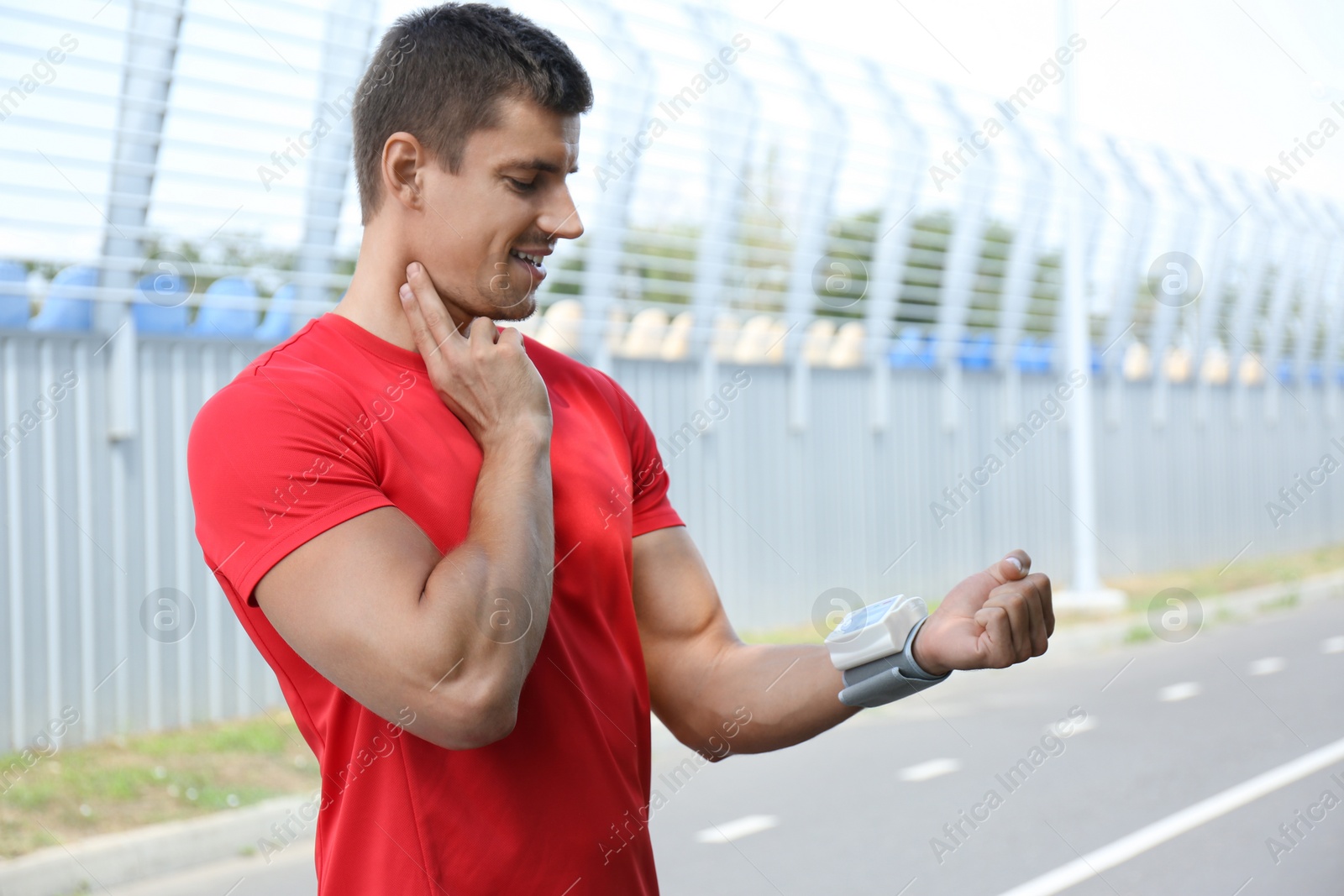 Photo of Young man checking pulse with medical device after training. Space for text