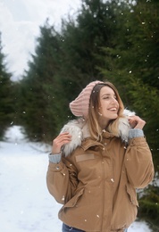 Young woman in snowy conifer forest. Winter vacation