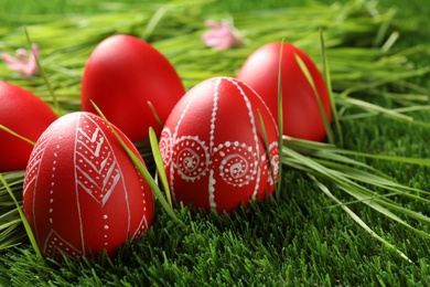 Red painted Easter eggs on green grass