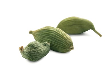 Dry green cardamom pods on white background, closeup