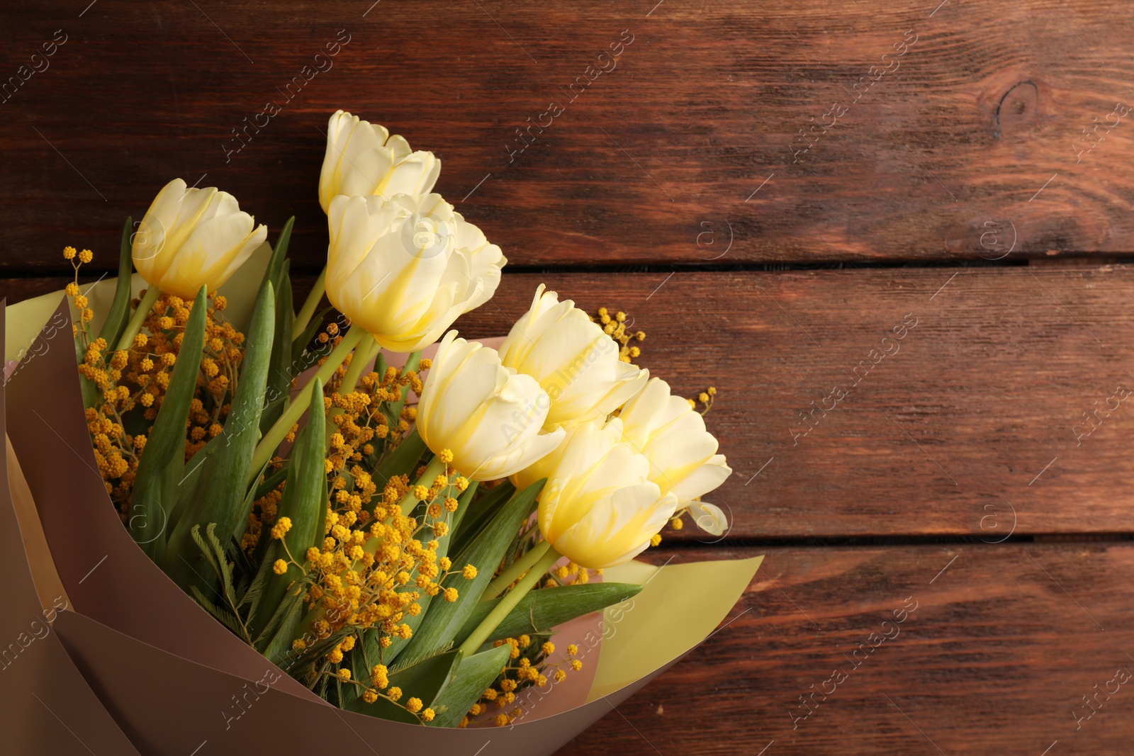 Photo of Bouquet with beautiful tulips and mimosa flowers on wooden table, top view. Space for text