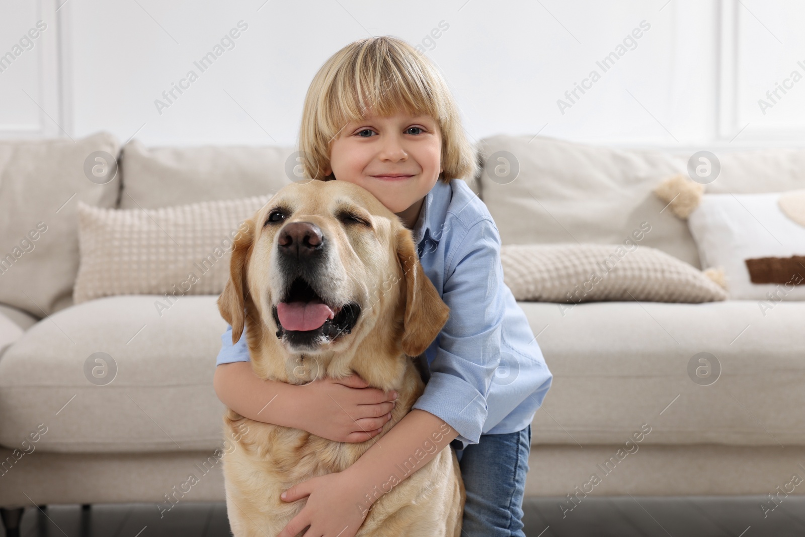 Photo of Cute little child with Golden Retriever at home. Adorable pet