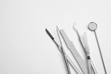Photo of Set of different dentist's tools and syringe on light background, flat lay. Space for text