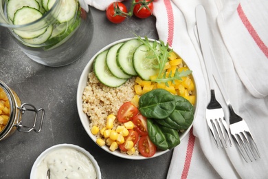 Photo of Healthy quinoa salad with vegetables in bowl served on grey table, top view