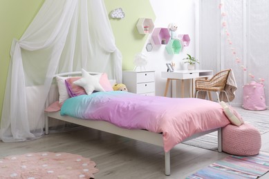 Photo of Cute child's room interior with toys and modern furniture