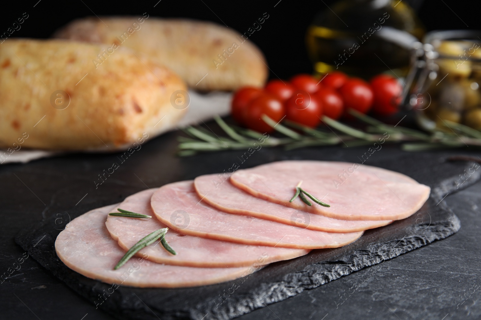 Photo of Slices of tasty ham on black table, closeup