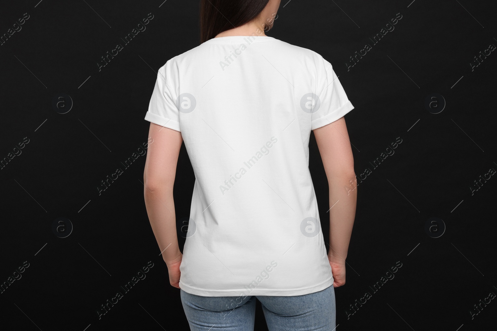 Photo of Woman wearing white t-shirt on black background, back view