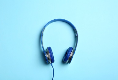 Stylish headphones on color background, top view