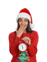 Photo of Woman in Santa hat with alarm clock on white background. New Year countdown