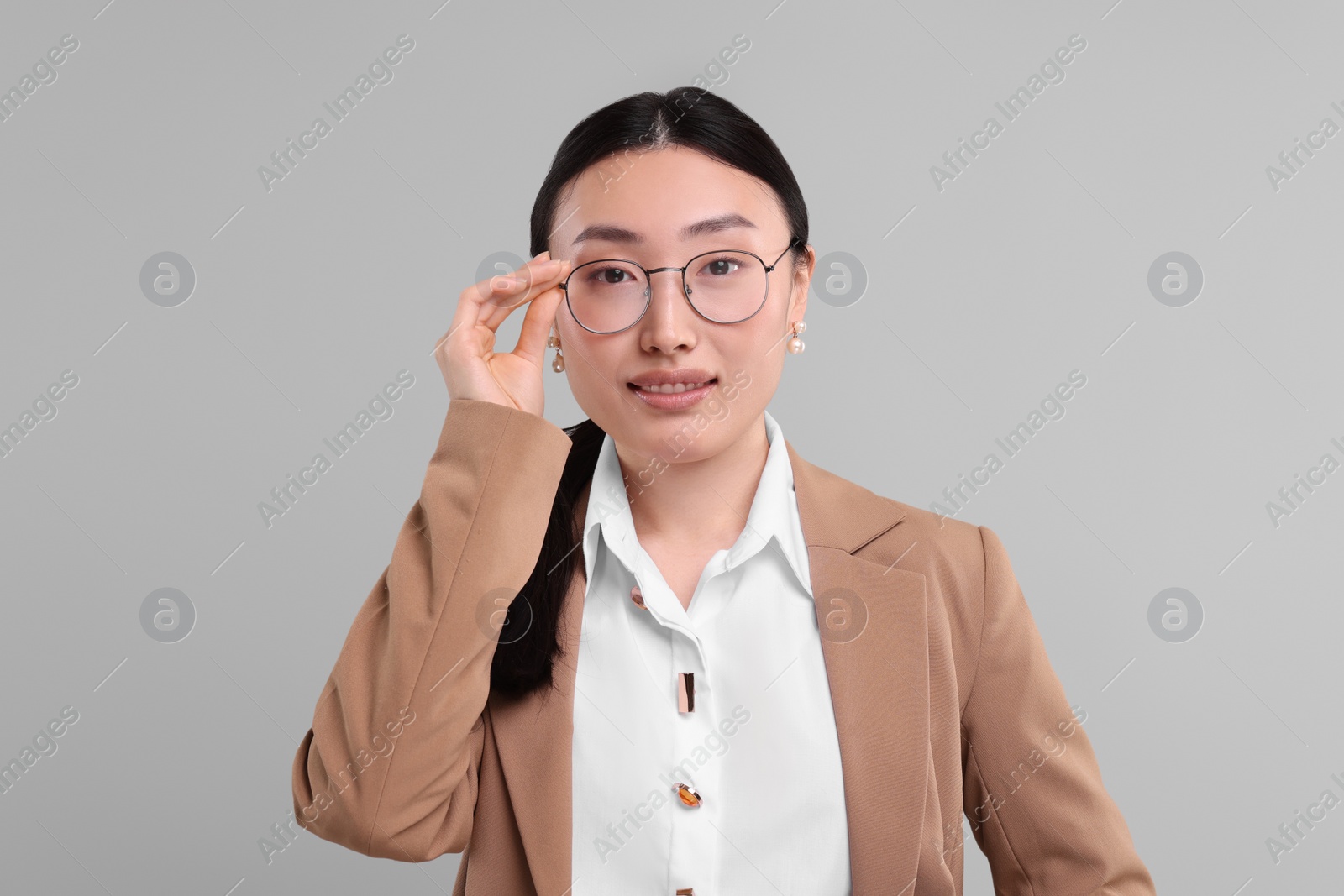 Photo of Portrait of smiling businesswoman on grey background