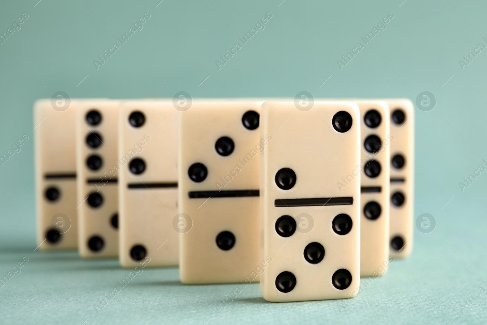 Photo of Classic domino tiles on grey background, closeup