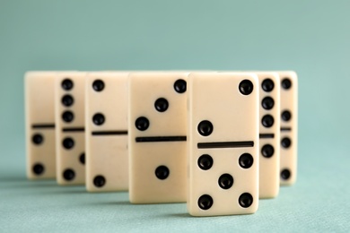 Photo of Classic domino tiles on grey background, closeup