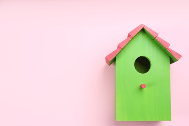 Photo of Beautiful bird house on pink background, top view. Space for text