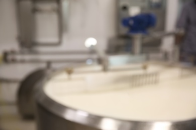 Blurred view curd preparation tank with milk at cheese factory